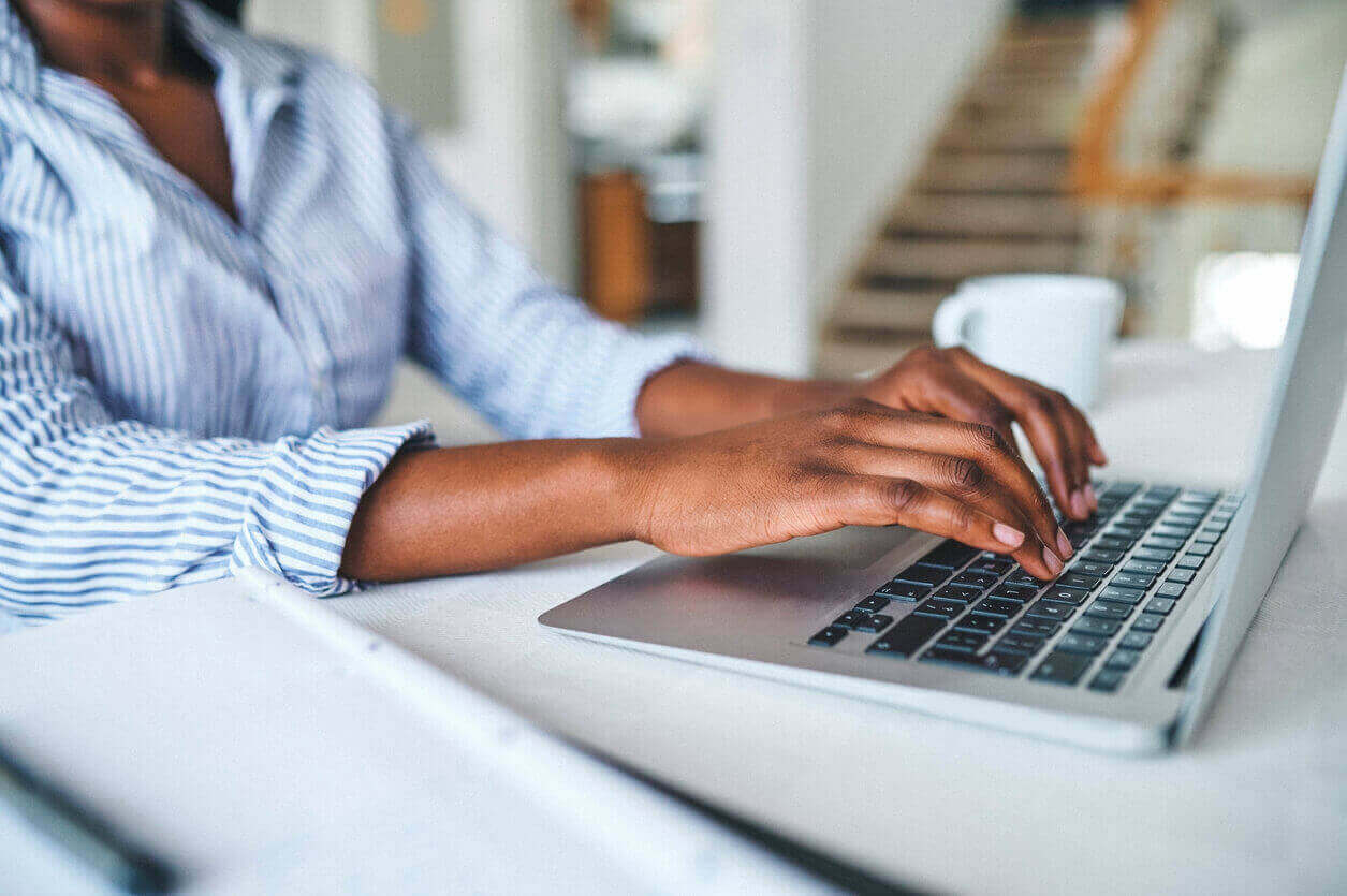 Closeup shot of an unrecognisable woman using a laptop at home